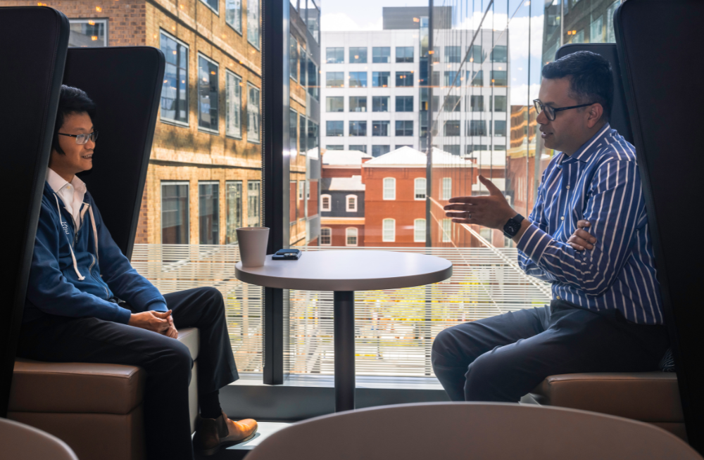 Two men sit opposite each other, in the middle of a conversation.