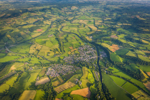 Country town surrounded by green fields pasture farmland aerial view
